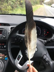 me holding a feather inside my car.